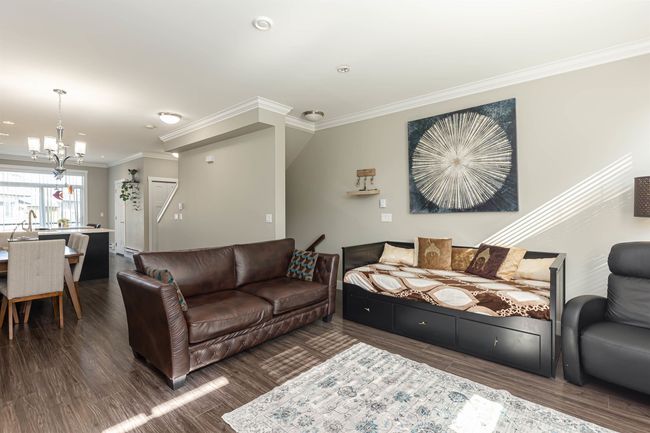 Living room with crown molding, a chandelier, and wood finished floors | Image 9