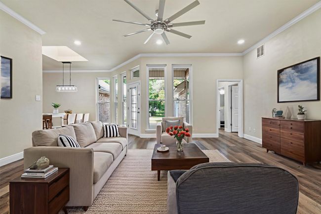 The living room looks out over the back patio and has plenty of space being the center of the house! (This photo has been virtually staged to show it's potential.) | Image 6