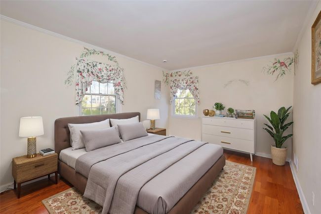 Bedroom featuring crown molding, baseboards, and wood finished floors | Image 7