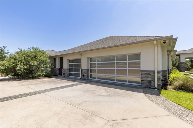 View of front of home featuring stone siding, stucco siding, concrete driveway, and a garage | Image 16