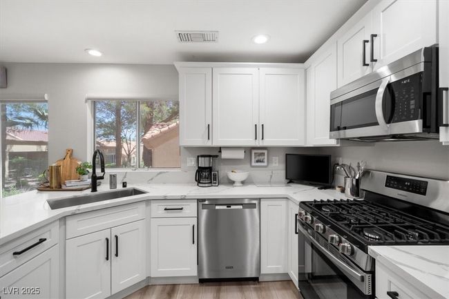 The gourmet chef’s kitchen is a masterpiece with quartz countertops, a touch-activated faucet, new sink, custom cabinetry, & premium stainless steel appliances. | Image 15