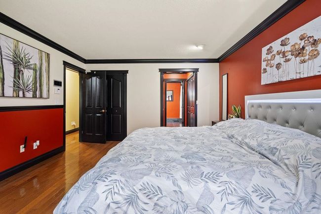 Bedroom featuring wood finished floors, crown molding, and baseboards | Image 19
