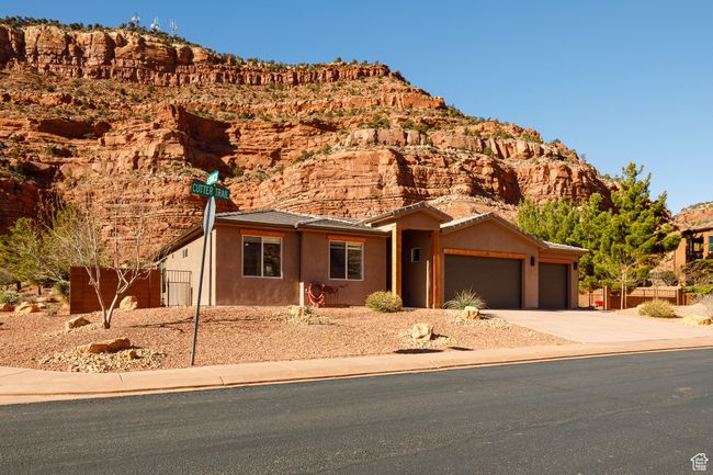 View of front facade with fence, an attached garage, stucco siding, driveway, and a mountain view | Image 4