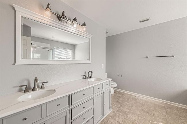 Luxurious primary en suite featuring double sinks, a soaking tub, and a separate shower. | Image 17