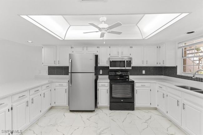 Kitchen featuring light tile patterned floors, stainless steel appliances, tasteful backsplash, and sink | Image 31