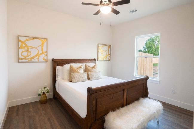 Bedroom with dark wood-style floors, baseboards, and ceiling fan | Image 24