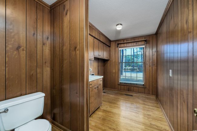 Bathroom with toilet, vanity, and wood walls | Image 18