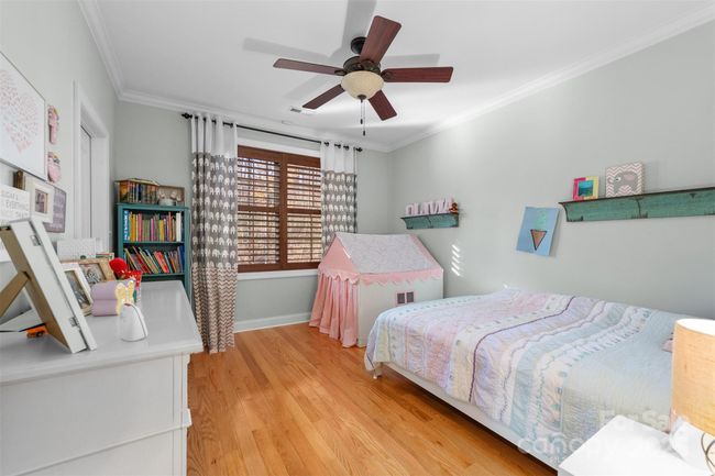 Second bedroom on main level offers walk in closet, hardwood floors and plantation blinds. | Image 20