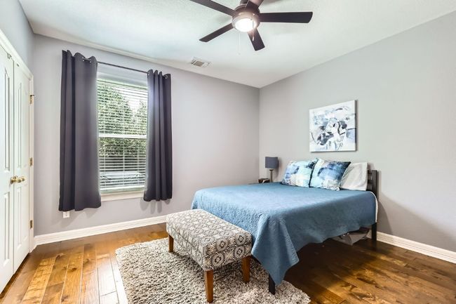 First floor bedroom with hardwood floor and a ceiling fan | Image 12