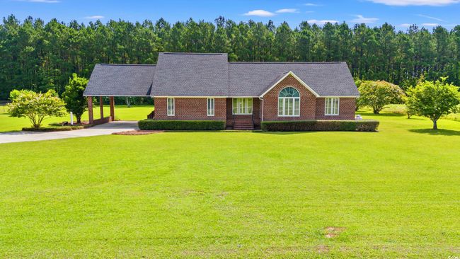 Single story home with a front lawn, a carport, concrete driveway, and brick siding | Image 24