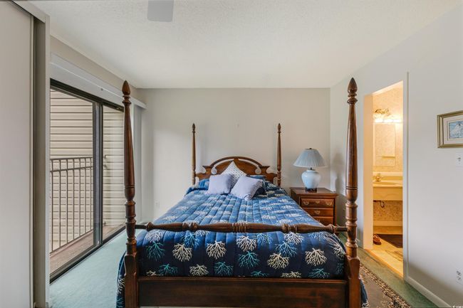 Bedroom with carpet flooring, access to exterior, ensuite bathroom, and a textured ceiling | Image 24