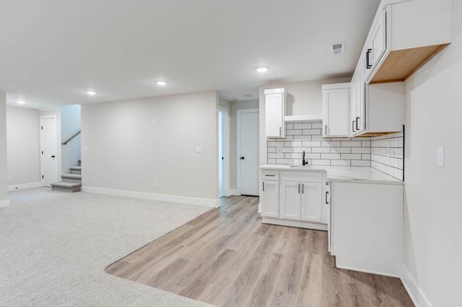 Kitchen with a sink, baseboards, recessed lighting, white cabinetry, and decorative backsplash | Image 24