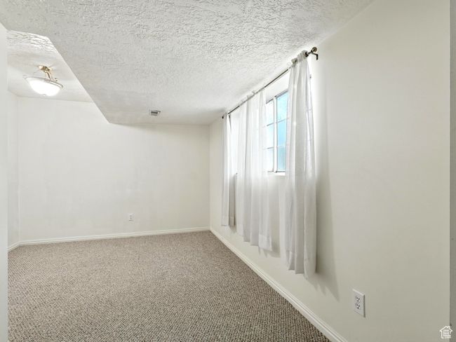 Carpeted spare room with a textured ceiling and baseboards | Image 11