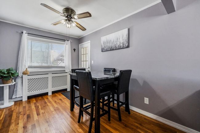 Dining space featuring crown molding, a ceiling fan, hardwood / wood-style flooring, and radiator | Image 4