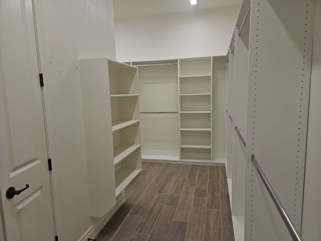 Walk in closet with dark wood-style flooring | Image 17