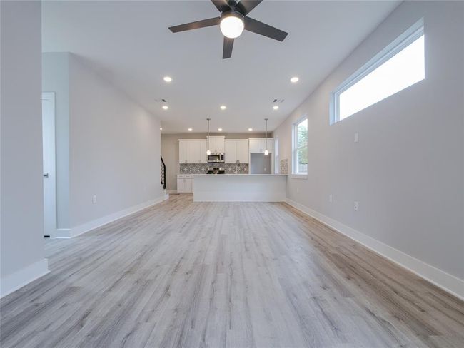 Unfurnished living room with a ceiling fan, recessed lighting, and light wood-style flooring | Image 5