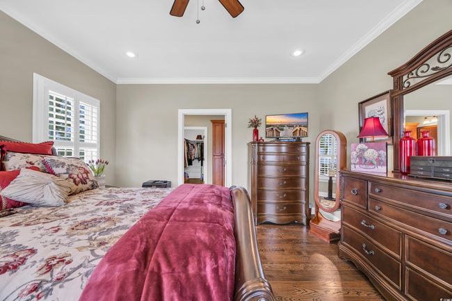Bedroom featuring dark wood finished floors, crown molding, ceiling fan, and recessed lighting | Image 18