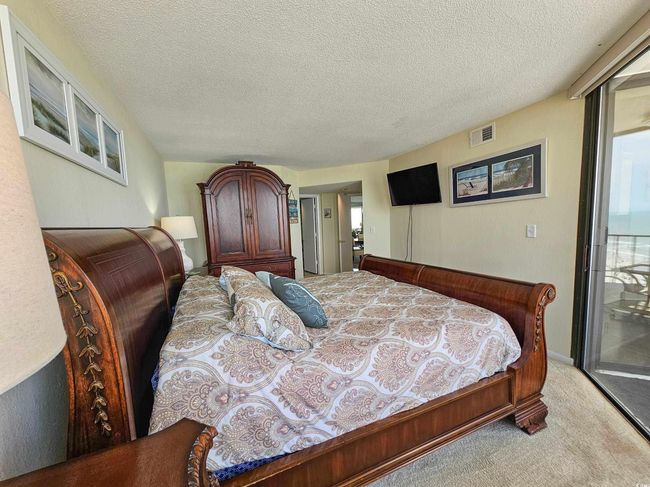 Bedroom featuring carpet floors, access to exterior, and a textured ceiling | Image 22