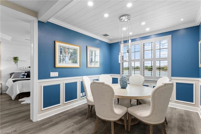 Dining space with ornamental molding, a decorative wall, recessed lighting, wainscoting, and wood finished floors | Image 11