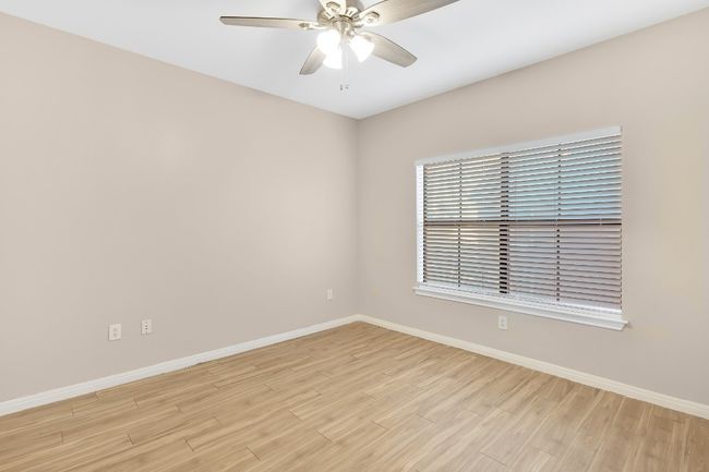 Primary bedroom with light wood finished floors, baseboards, and new ceiling fan, and new blinds. | Image 11
