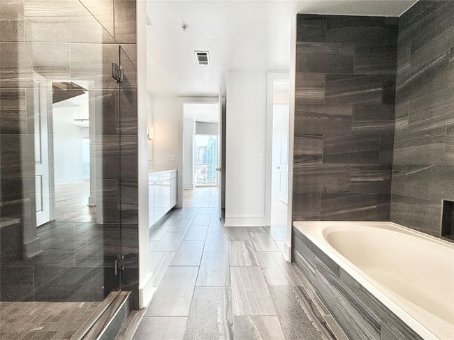 Full bath featuring a bath, a shower stall, and baseboards | Image 21