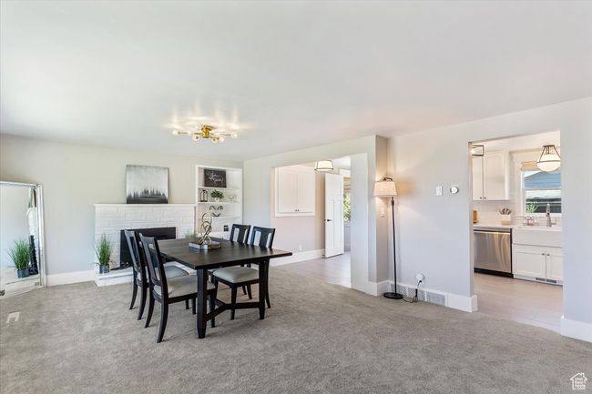 Dining space featuring light colored carpet and a fireplace | Image 11