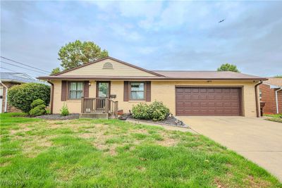 Ranch-style home with a front yard and a garage | Image 1