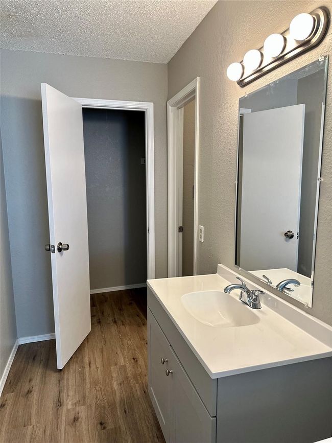 Bathroom featuring wood finished floors, vanity, and a textured ceiling | Image 6