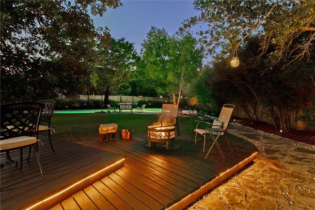 Wooden deck featuring a lawn, a fenced backyard, and a fire pit | Image 46