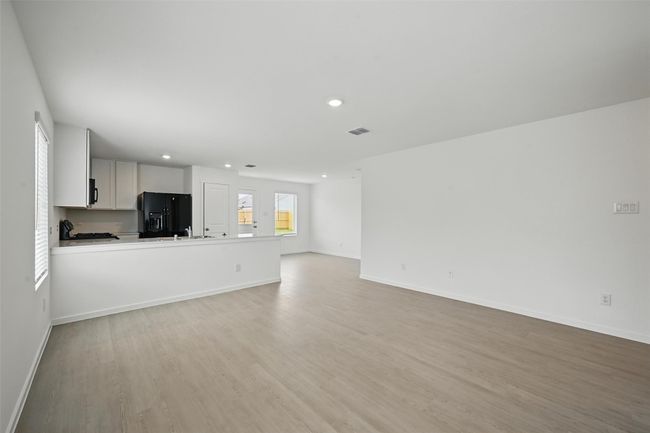 Unfurnished living room with light wood finished floors and recessed lighting | Image 4