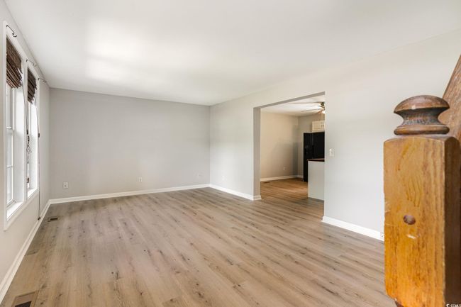Spare room featuring baseboards, visible vents, a ceiling fan, and light wood-style floors | Image 5