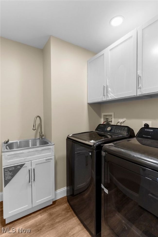 Laundry room featuring washer and clothes dryer, cabinet space, light wood-style floors, and recessed lighting | Image 12