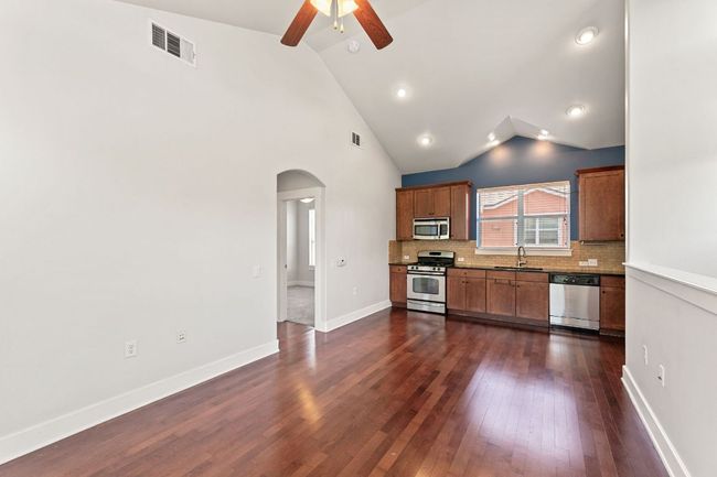 Kitchen with stainless steel appliances, arched walkways, vaulted ceiling, ceiling fan, and decorative backsplash | Image 12