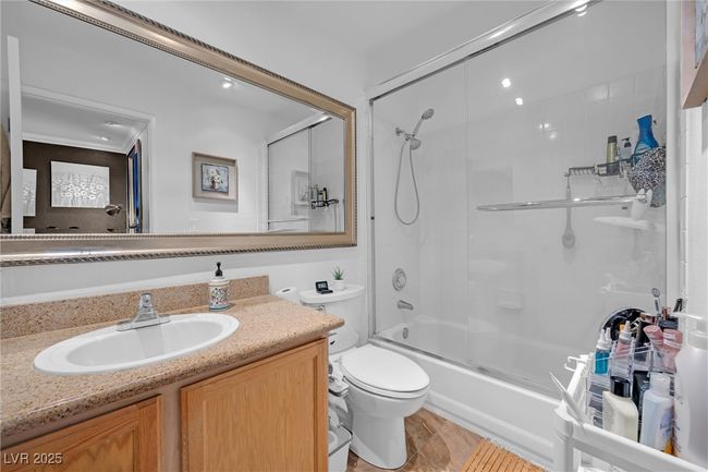 Bathroom featuring toilet, vanity, and shower / bath combination with glass door | Image 18
