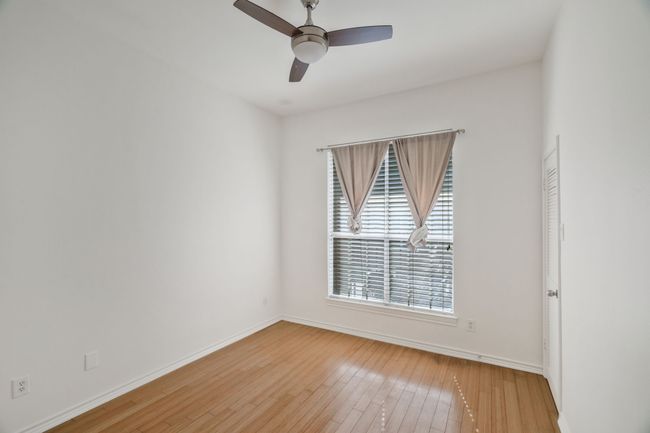 Empty room with hardwood / wood-style flooring, baseboards, and ceiling fan | Image 12