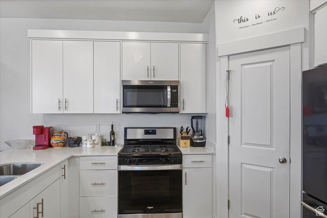 Kitchen featuring light countertops, appliances with stainless steel finishes, and white cabinetry | Image 7