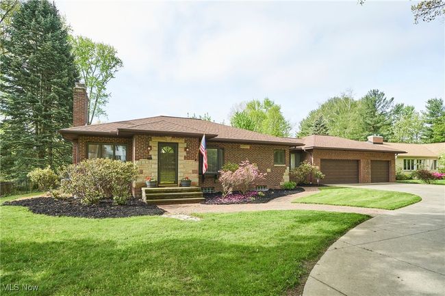 View of front of home with a chimney, an attached garage, driveway, and a front lawn | Image 24