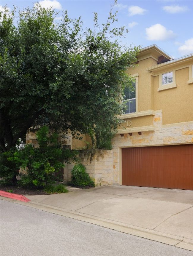 View of front of property with stone siding, stucco siding, an attached garage, and concrete driveway | Image 35