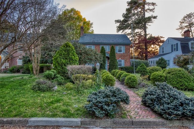 Colonial-style house featuring brick siding, a chimney, and a front lawn | Image 26