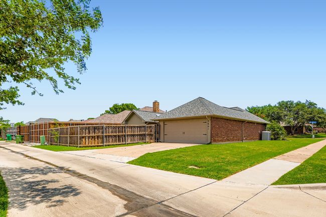 View of property exterior with brick siding, an attached garage, concrete driveway, and roof with shingles | Image 23