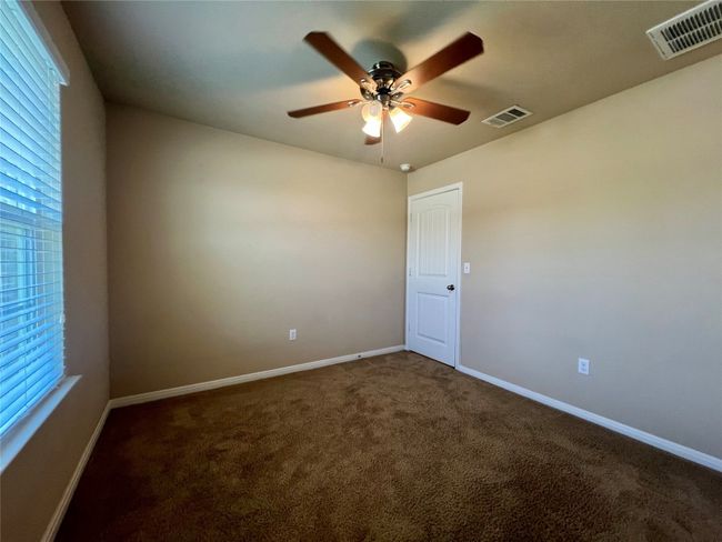 Carpeted empty room with a ceiling fan, baseboards, and healthy amount of natural light | Image 5