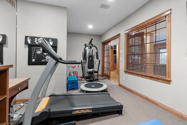 Lower-level exercise room with space for several machines and weights. Mirrored walls and French, windowed doors to lower-level hallway. | Image 50