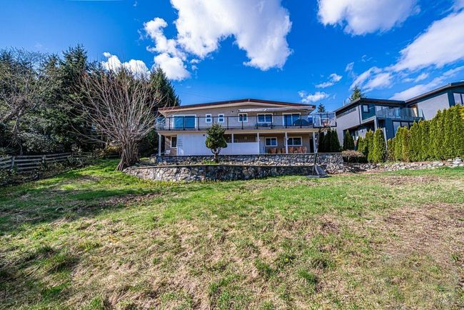 Rear view of house featuring fence, a lawn, and a balcony | Image 39