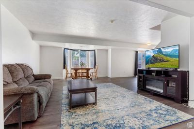 Living room featuring a textured ceiling and dark hardwood / wood-style flooring | Image 3