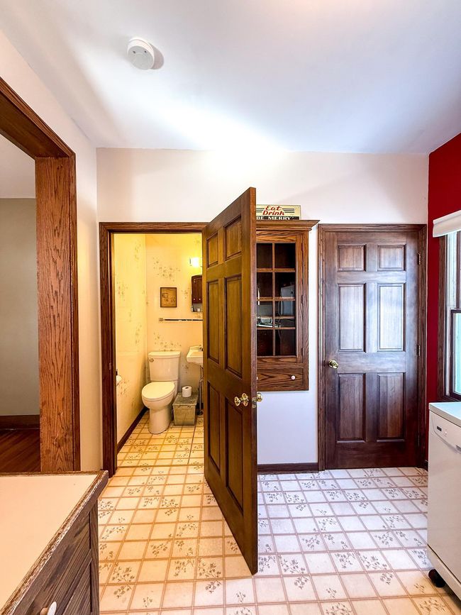 Bathroom, storage, and basement access complement the kitchen | Image 9