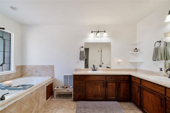 Full bath featuring a bath, tile patterned flooring, a sink, and double vanity | Image 13