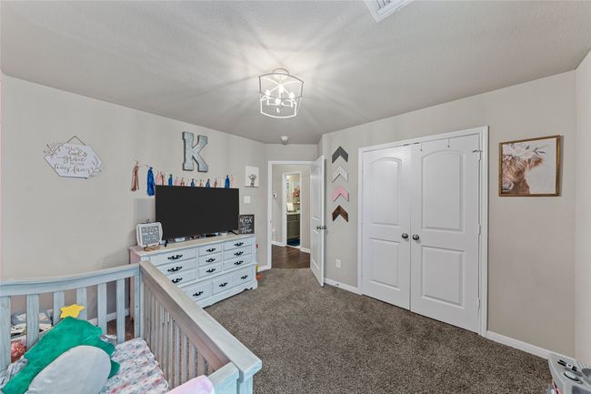 Carpeted bedroom with a chandelier, baseboards, and a closet | Image 10