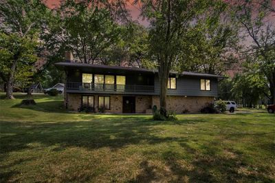 Back house at dusk featuring a lawn | Image 1