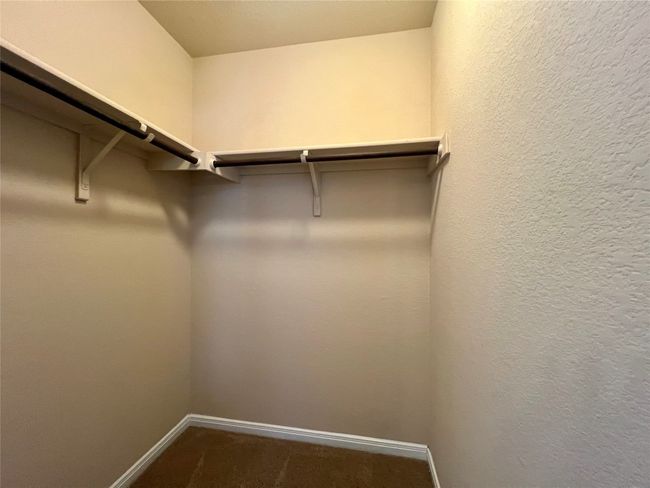 Spacious closet with dark carpet | Image 6