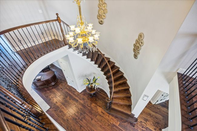 Staircase featuring a notable chandelier and wood-type flooring | Image 24